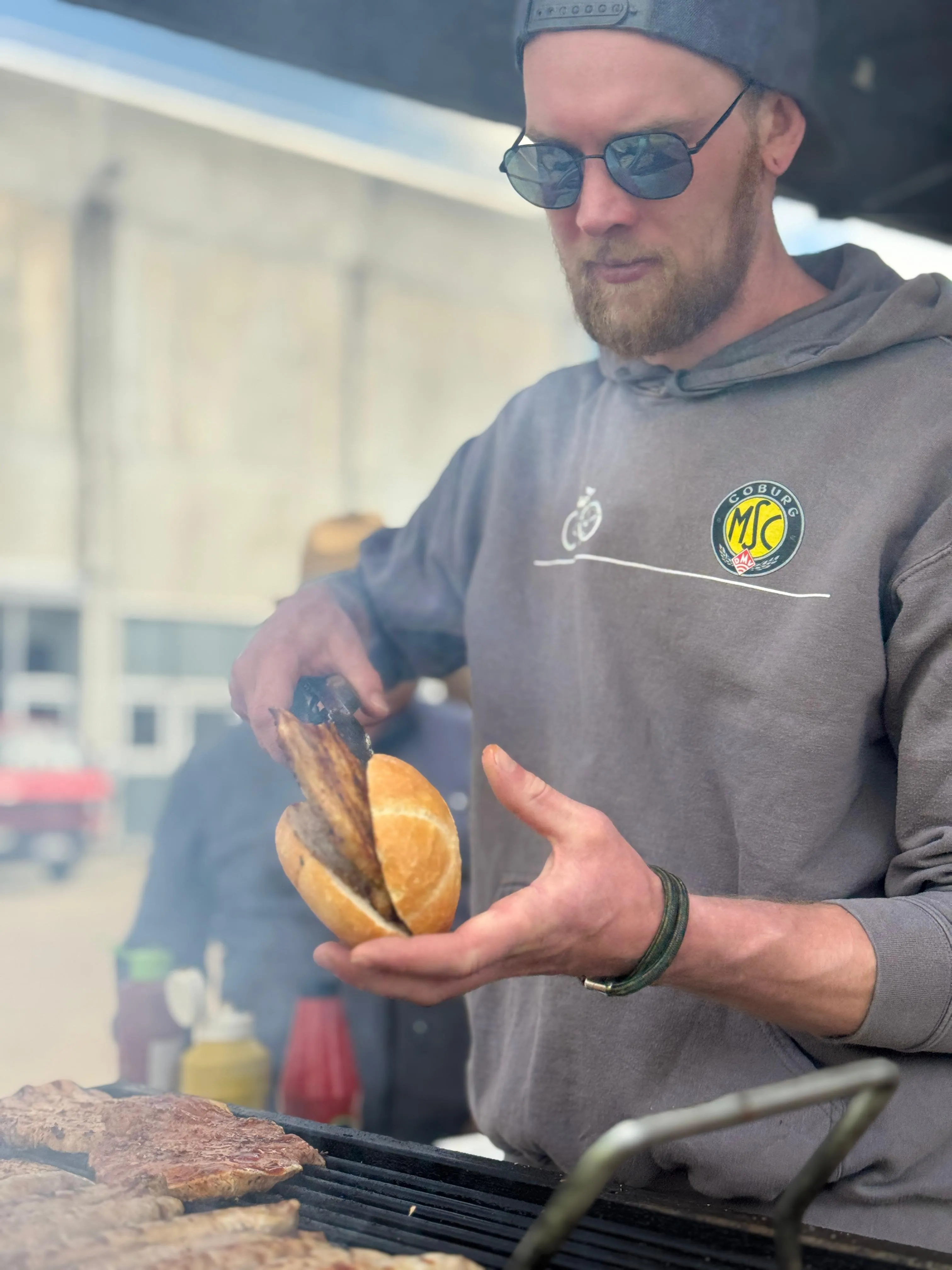 MSC-Mitglied beim Grillen mit Grillzange und Brötchen