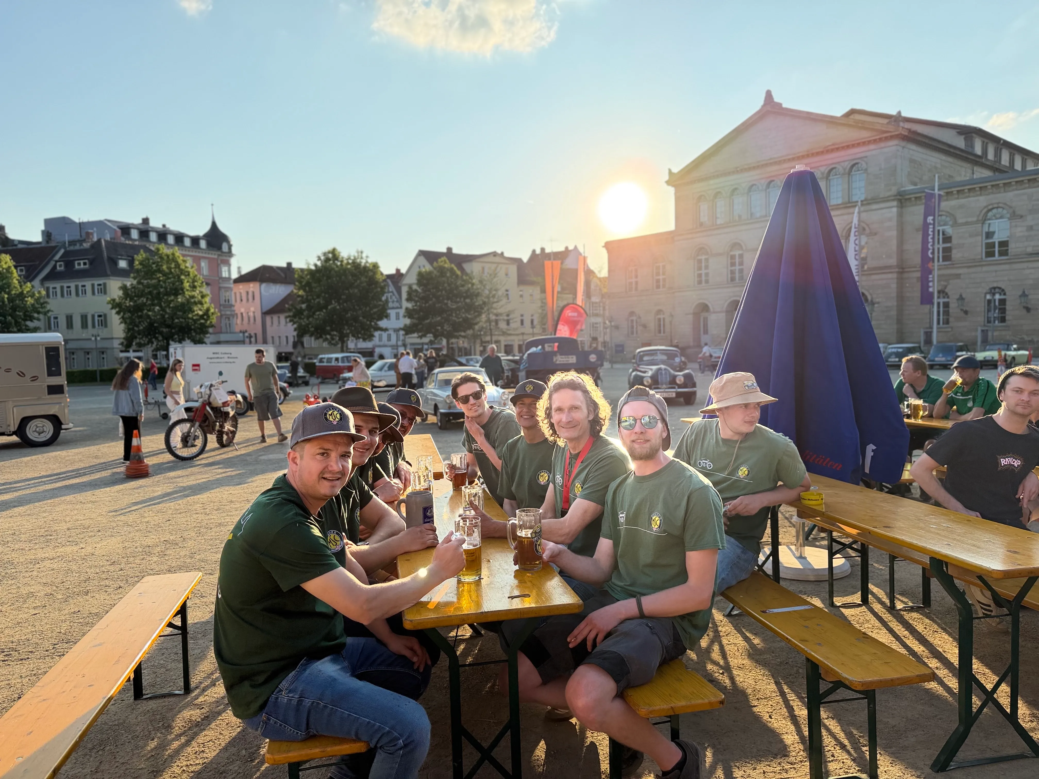 MSC-Mitglieder gemeinsam an einer Biertischgarnitur auf dem Coburger Schlossplatz in der Abendsonne